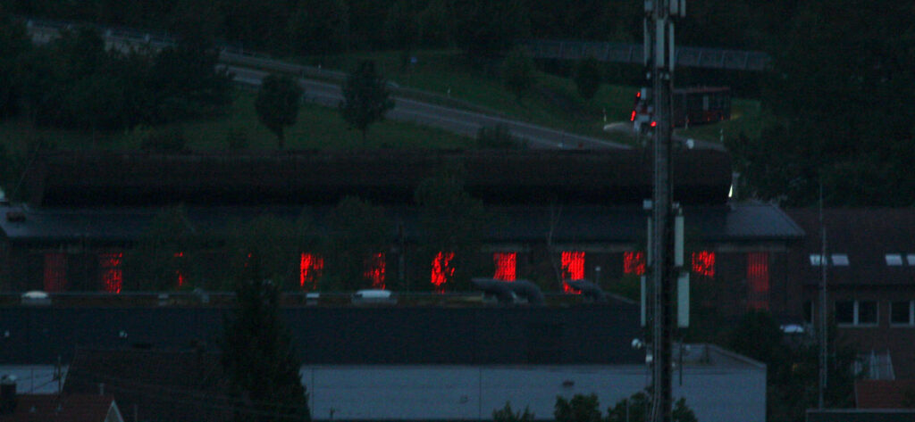 Metzingen und seine Outlets bei Nacht von oben in einer Augustsommernacht.